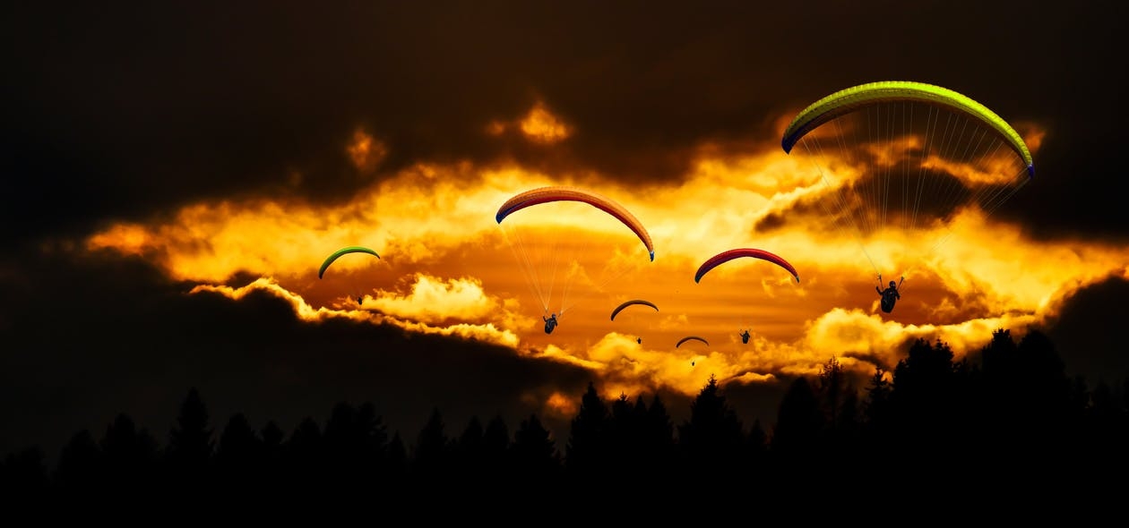 https://www.pexels.com/photo/people-in-mid-air-using-parachute-in-dusk-221191/