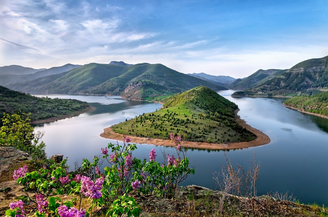 https://www.pexels.com/photo/green-mountain-surrounded-by-body-of-water-photo-225203/